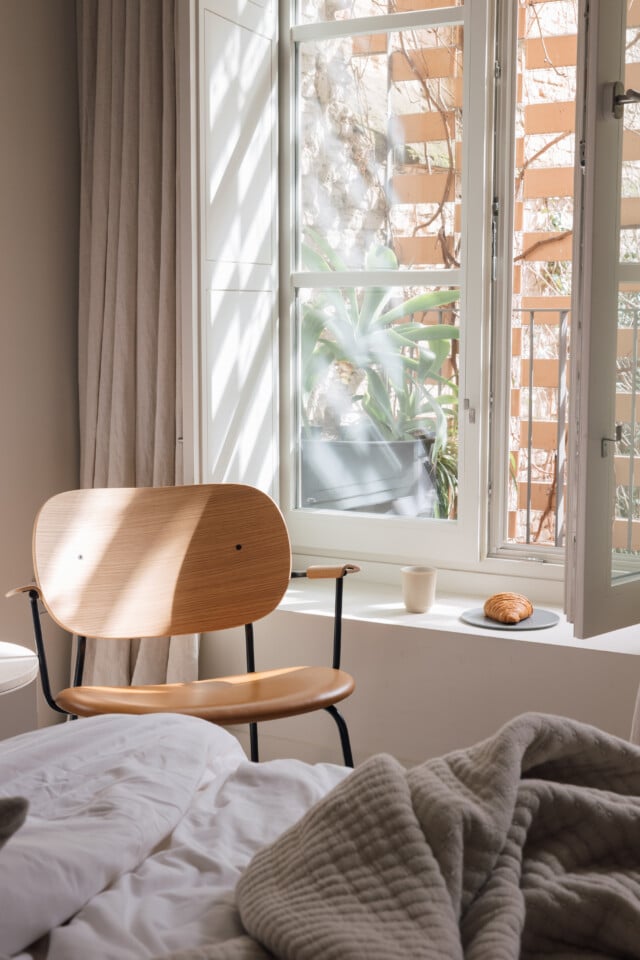 Rincón de una de las habitaciones del hotel boutique Plácido y Grata con mobiliario de diseño y materiales naturales, iluminado por la luz natural de la ciudad de Sevilla.